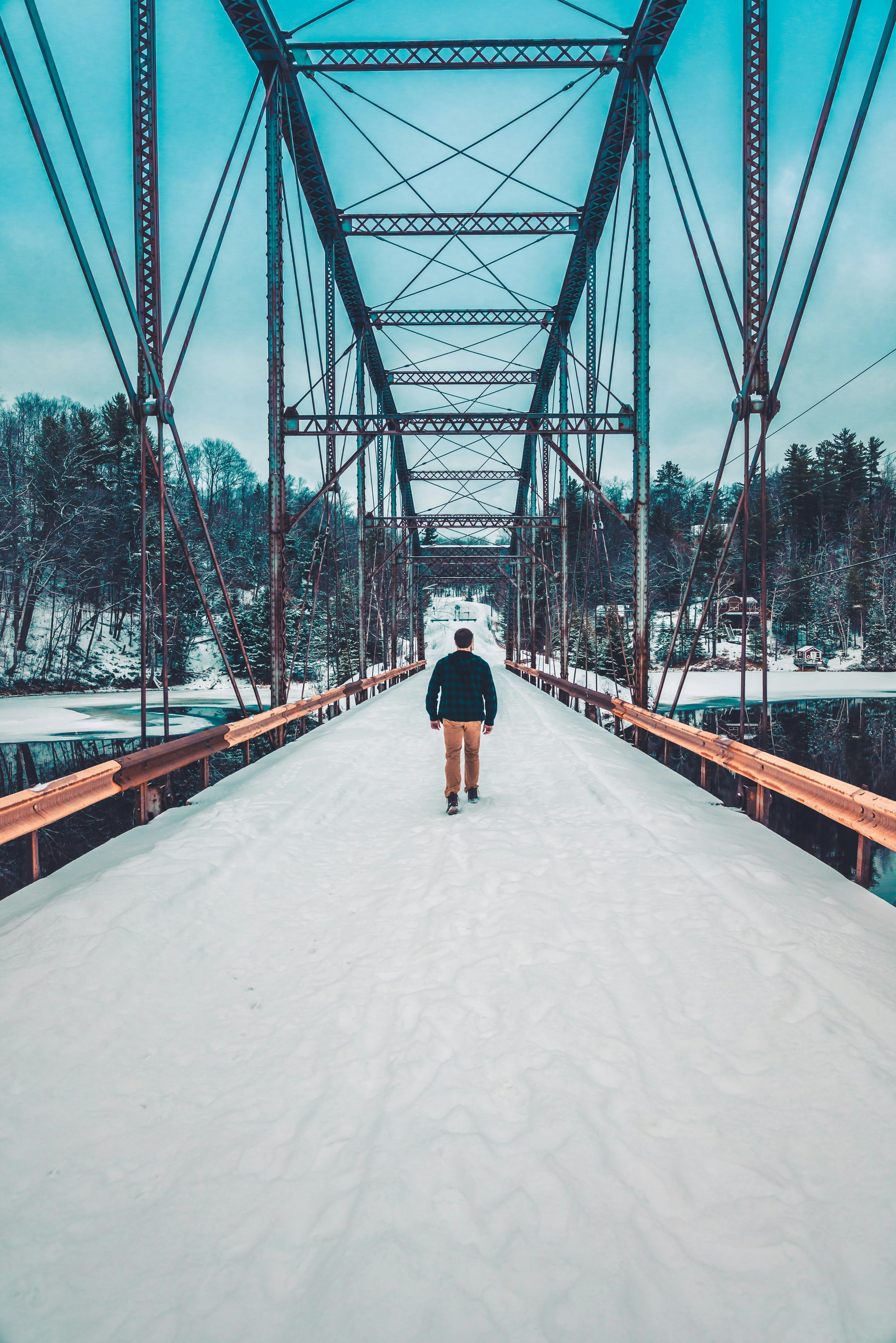 man walking on bridge during daytime